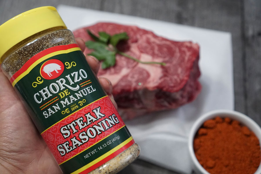 can of seasoning in front of prime steaks from Chorizo De San Manuel