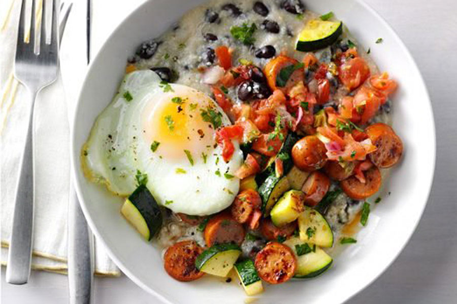Start Your Day with a Hearty Mexican Chorizo and Grits Breakfast Bowl! 1 white bowl filled with fluffy scrambled eggs and the best chorizo brand, our Mexican chorizo San Manuel!