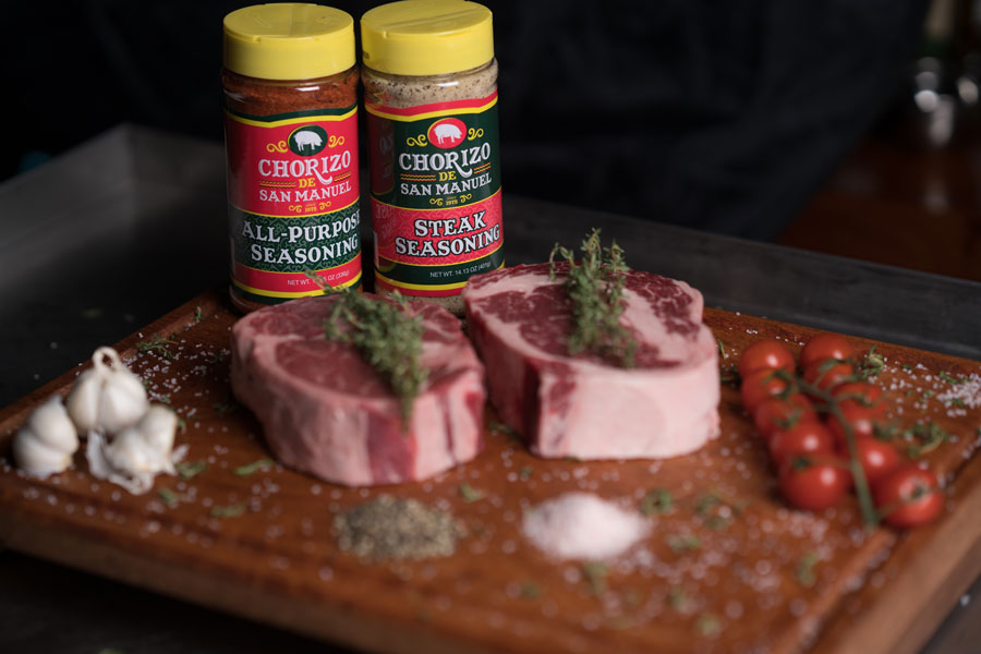 Platter with prime steaks and two bottles of signature Texas brand chorizo seasonings.