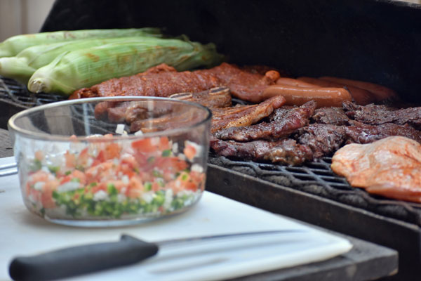 bowl of pico de Gallo on counter next to large cuts of prime steaks