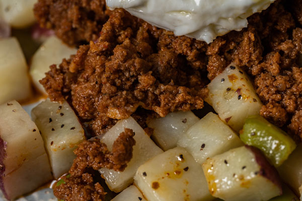 Beef Mexican chorizo topped over boiled cubed potatoes peices.