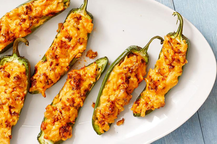 Baked Jalapeno and Mexican chorizo poppers plated on a large dish platter on top of table.