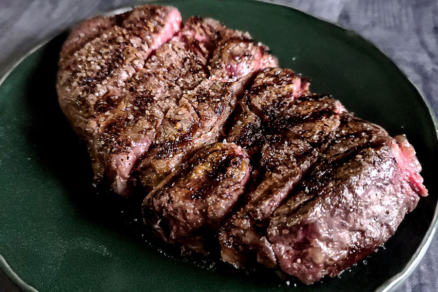 Prime steak tenderloin slabbed on green plate.