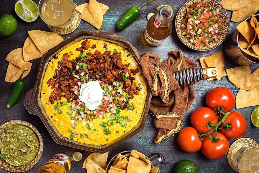 3 Mexican Chorizo Recipes Perfect for Hosting the Holidays 1 Chicken choriqueso made with famous chicken chorizo next to vegetables.