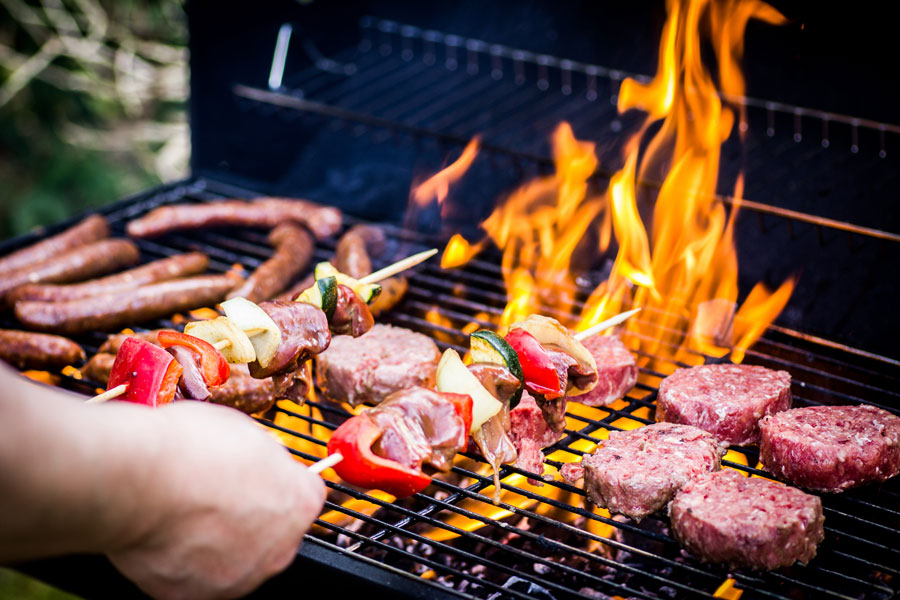 person grilling prime beef products on pit.