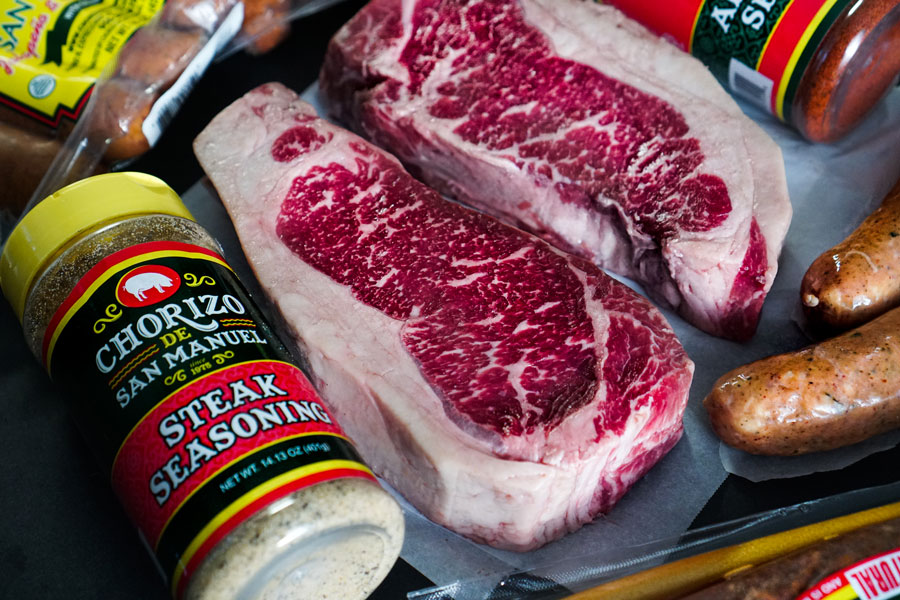 cut porterhouse prime beef product on a wooden counter.