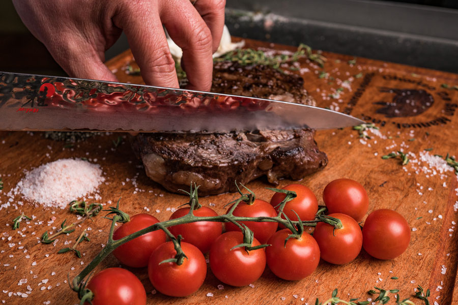 Medium rare prime beef product on wooden slab from Chorizo de San Manuel