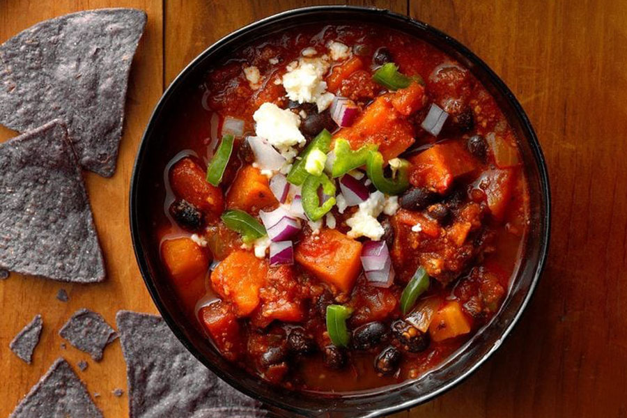 Try a 6 Hour Slow-Cooked Mexican Chorizo and Sweet Potato Chili 1 warm bowl of chili and Mexican chorizo with blue corn tortilla chips.